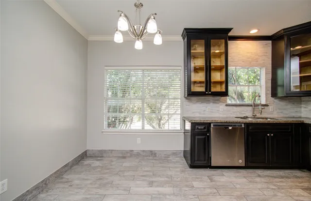 a view of kitchen with granite countertop cabinets and window