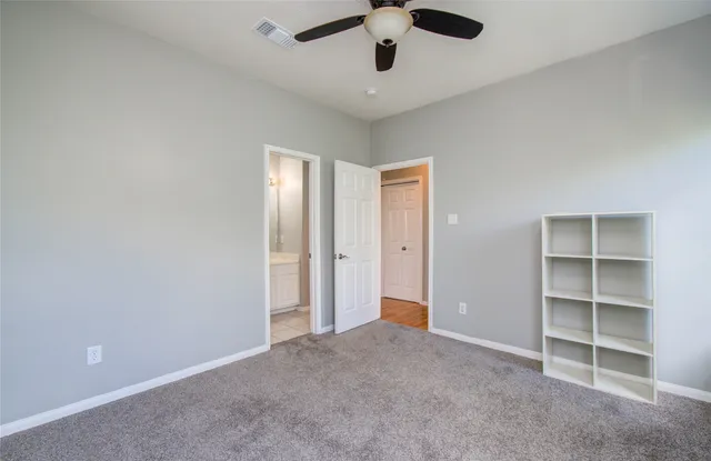 a view of an empty room with a cabinet and a window