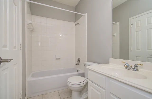 a bathroom with a granite countertop sink a toilet and shower