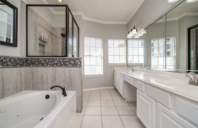a spacious bathroom with a tub sink and mirror