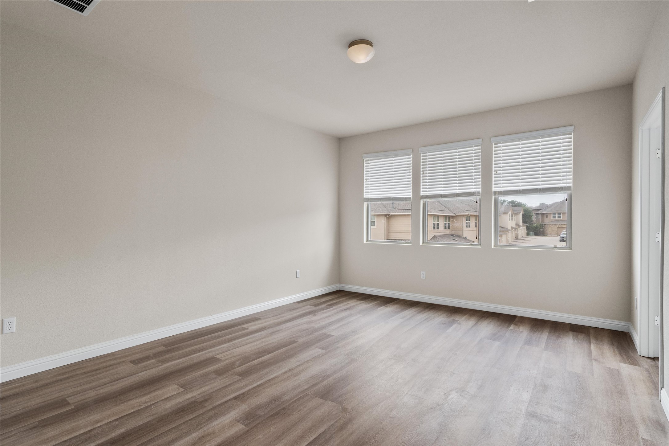 6907 Idea Road Austin, TX 78741 - Photo 23 of 36 a view of an empty room with wooden floor and a window