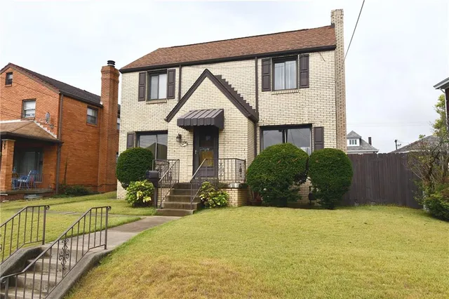 a view of a house with backyard and sitting area