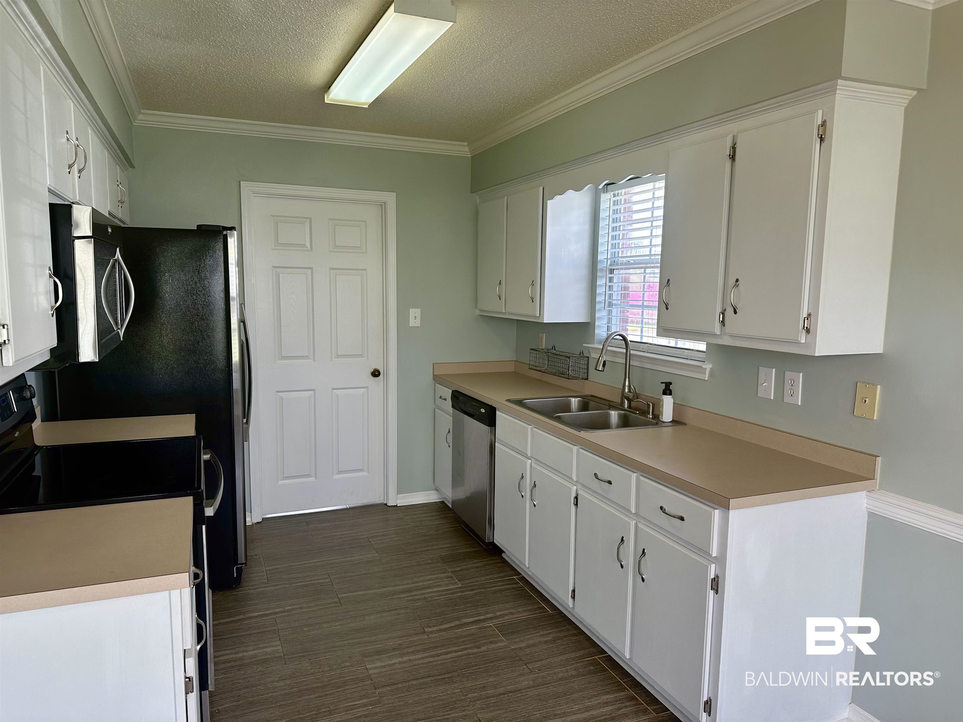 4882 Rebecca Place Mobile, AL 36695 - Photo 25 of 29 Kitchen featuring a sink, light countertops, white cabinets, stainless steel appliances, and dark wood-style flooring