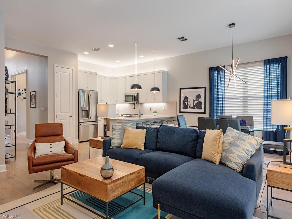 12456 Violet Lane Naples, FL 34120 - Photo 11 of 34 a living room with furniture kitchen view and a chandelier
