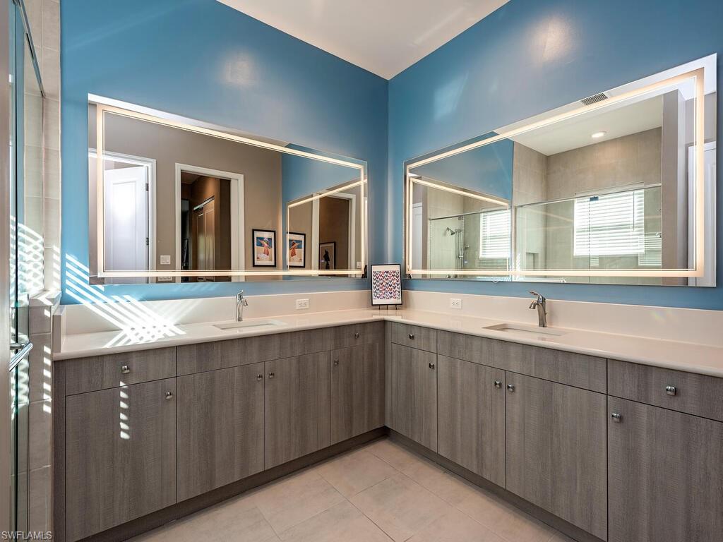 12456 Violet Lane Naples, FL 34120 - Photo 15 of 34 a spacious bathroom with a double vanity sink and mirror