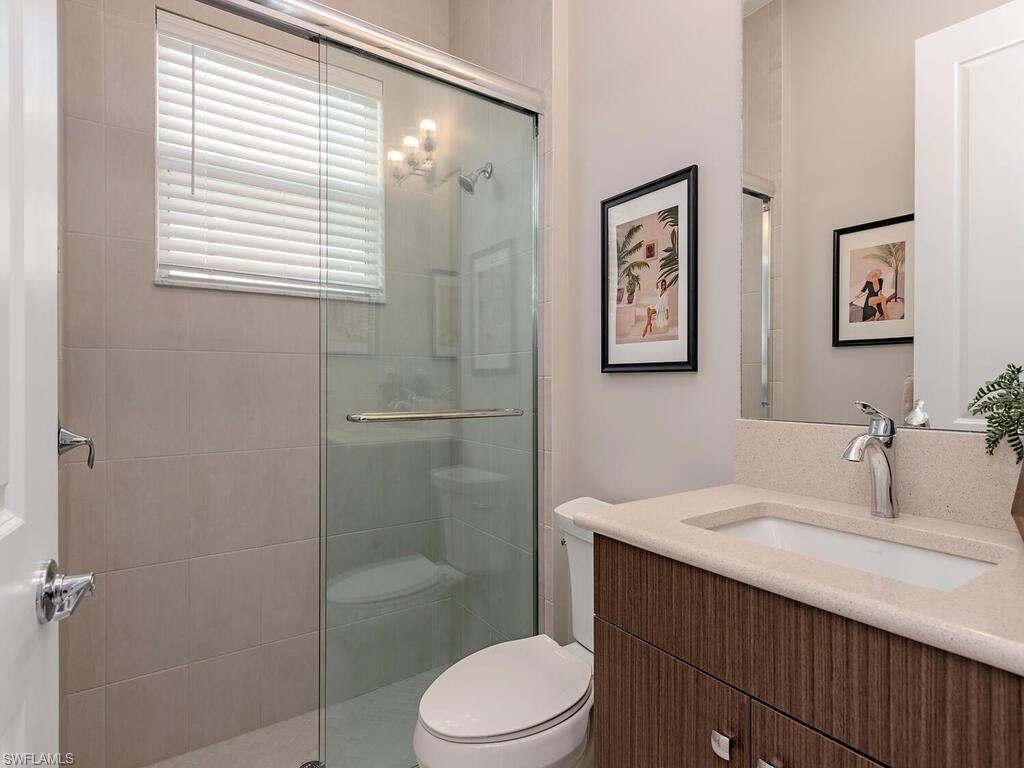 12456 Violet Lane Naples, FL 34120 - Photo 18 of 34 a bathroom with a sink a toilet and shower