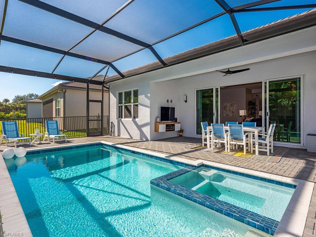 12456 Violet Lane Naples, FL 34120 - Photo 23 of 34 a view of a backyard with swimming pool table and chairs