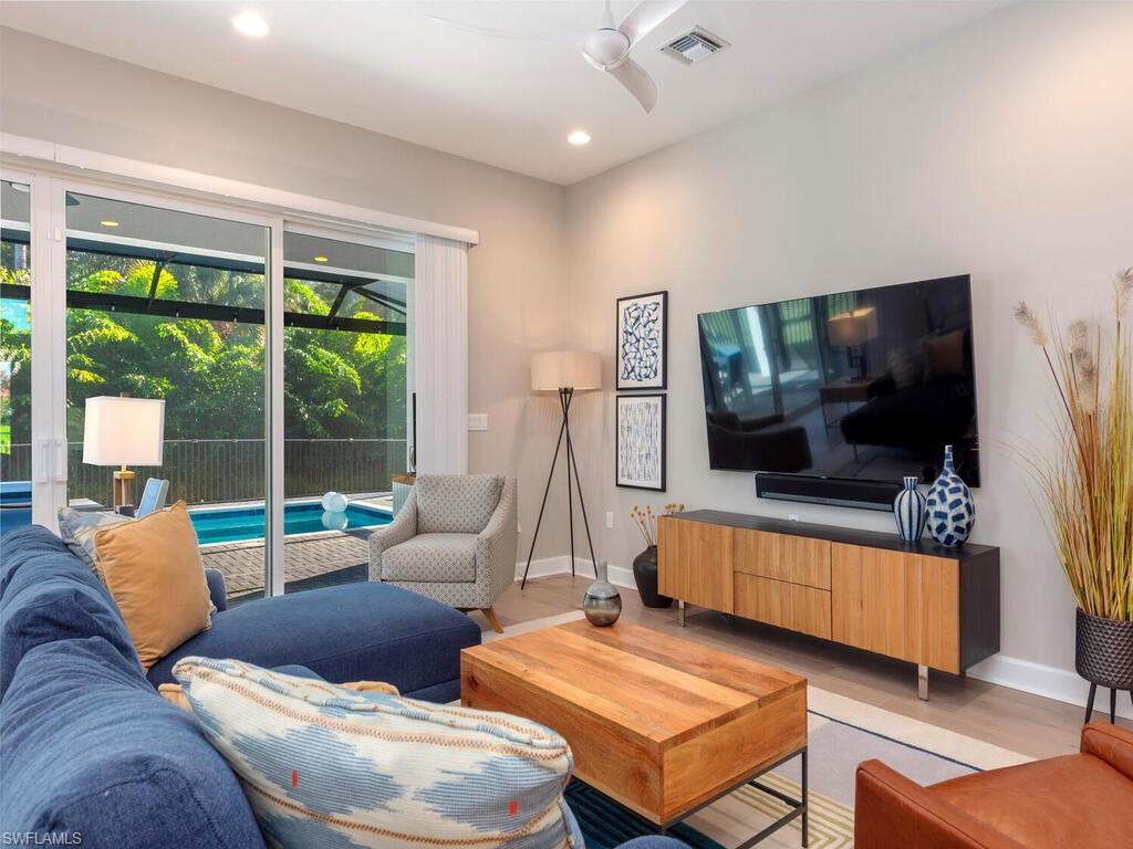 12456 Violet Lane Naples, FL 34120 - Photo 8 of 34 a living room with furniture and a flat screen tv