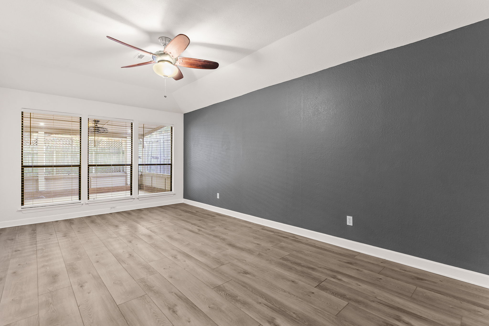 2409 Water Well Lane Austin, TX 78728 - Photo 12 of 22 Spacious room featuring wood-finish flooring, a vaulted ceiling, and a ceiling fan with integrated lighting