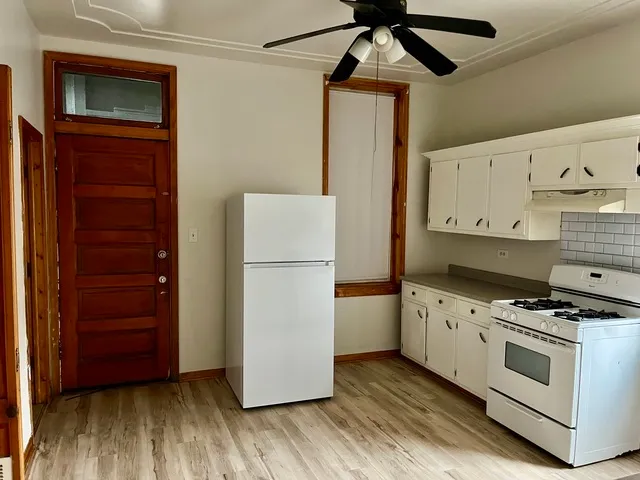 a kitchen with wooden floors and white cabinets