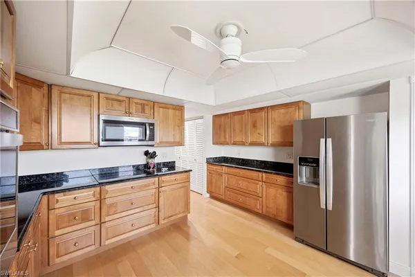 a kitchen with granite countertop a sink a counter space appliances and cabinets