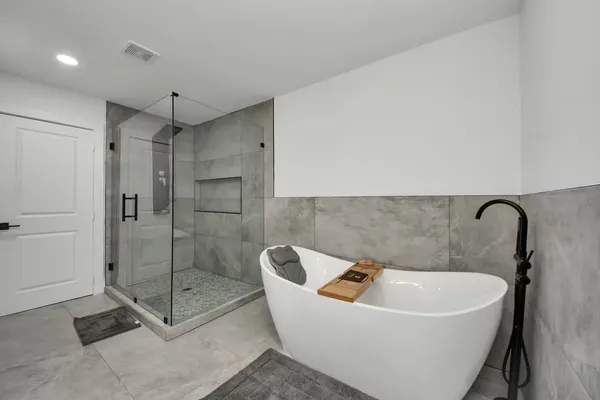 a white bath tub sitting next to a shower