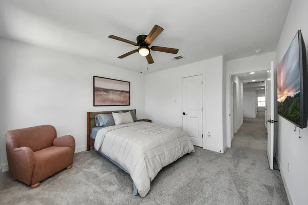 a spacious bedroom with a bed and a chandelier
