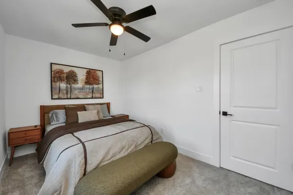 a bedroom with a bed and a painting on the wall