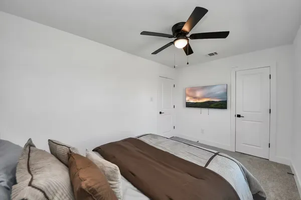 a bedroom with a bed and a ceiling fan