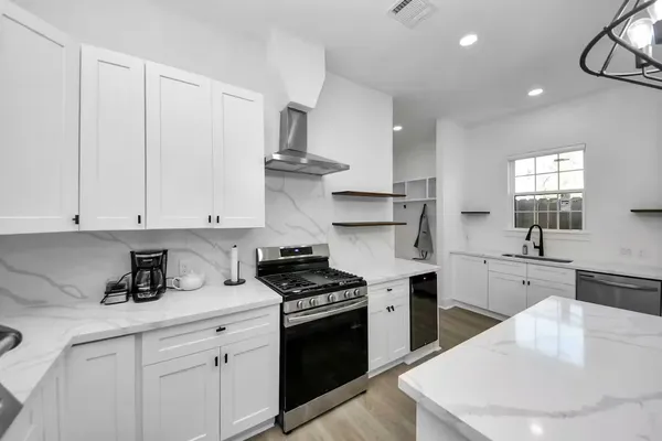 a kitchen with white cabinets and appliances