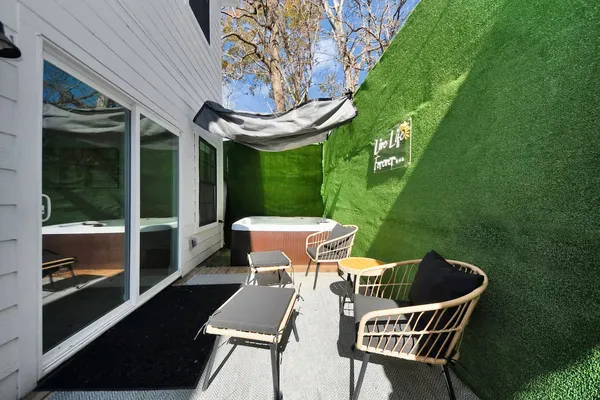 a view of a chair and table in the patio next to a yard
