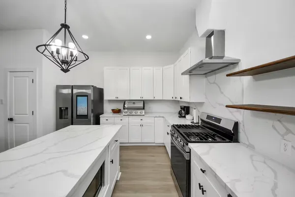 a kitchen with a stove and a chandelier