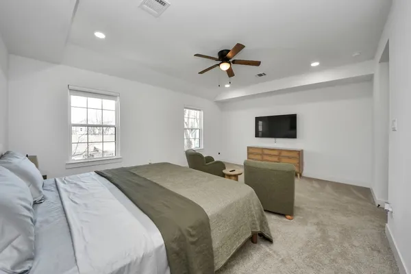 a bed room with a bed a window a television and a window