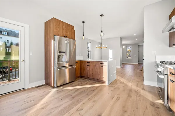 a kitchen with stainless steel appliances a refrigerator and a wooden floor
