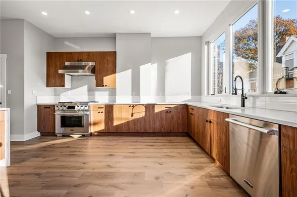 a large kitchen with stainless steel appliances granite countertop a stove and a sink