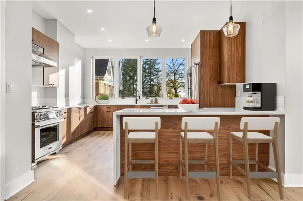 a kitchen with stainless steel appliances kitchen island granite countertop a stove a sink and a refrigerator