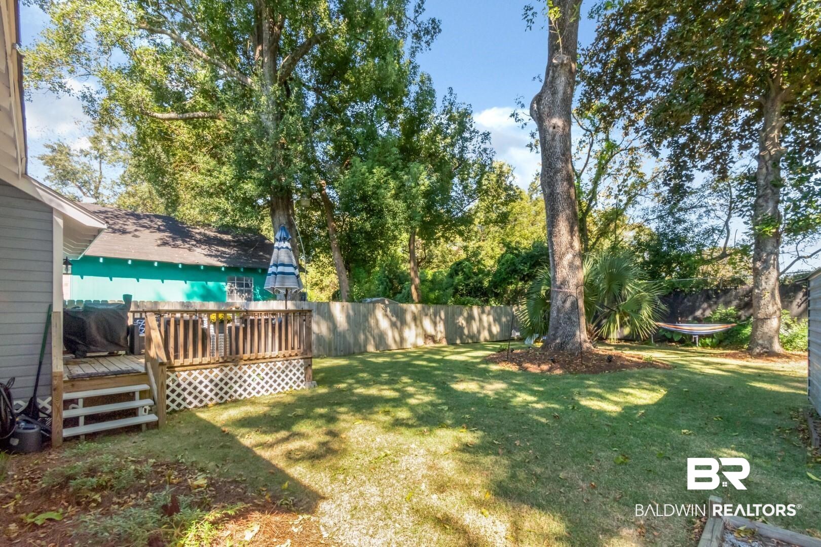 116 Item Avenue Mobile, AL 36607 - Photo 26 of 33 View of yard featuring a deck and a trampoline