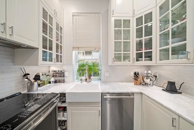 a kitchen with a sink and a stove next to a window