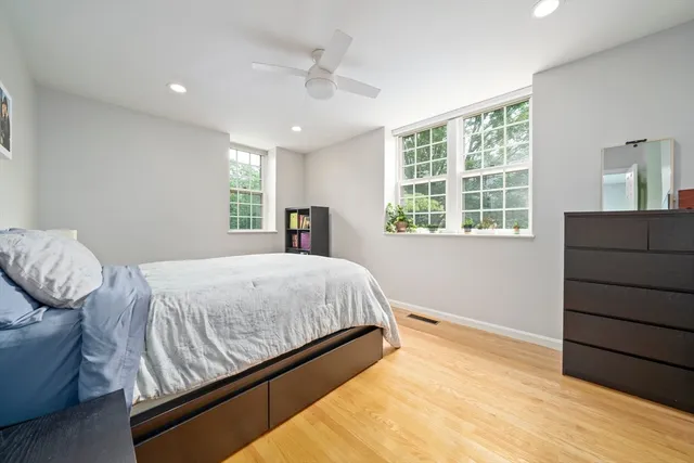 a bed sitting in a bedroom next to a window and dresser