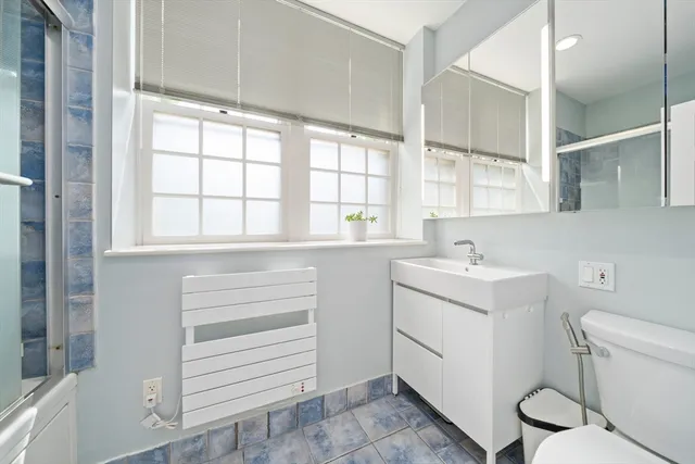 a bathroom with a sink toilet and window