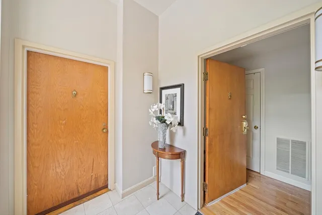 a view of a hallway with wooden floor and a dining room
