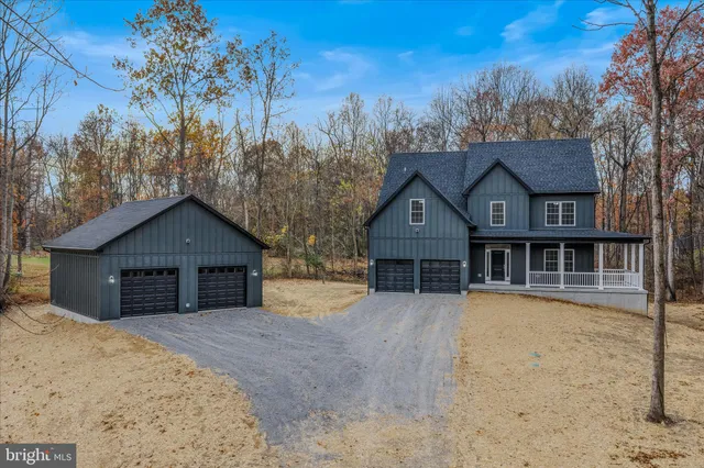 an empty room with chandelier fan and windows