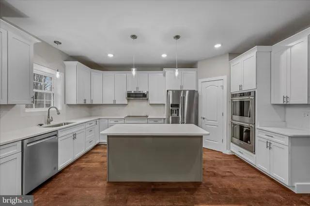 a view of an empty room with a chandelier fan