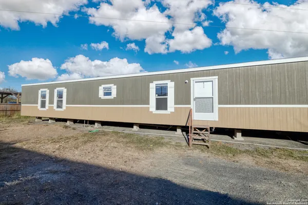 a view of a house with backyard and sitting area
