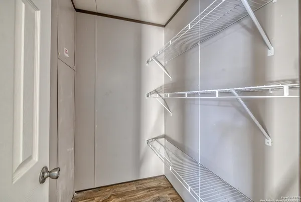 a view of walk in closet with wooden floor