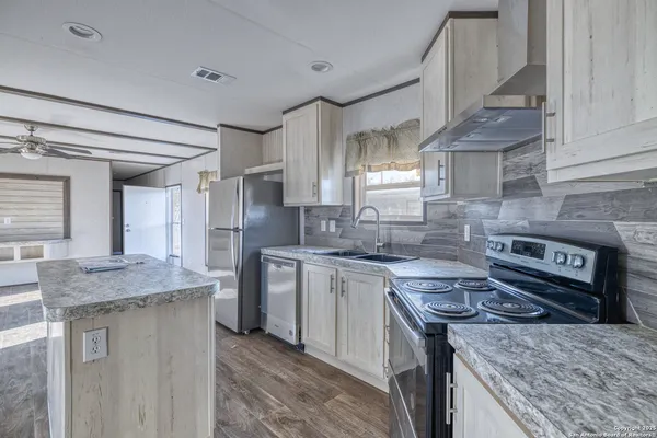 a kitchen with stainless steel appliances granite countertop a sink stove and refrigerator