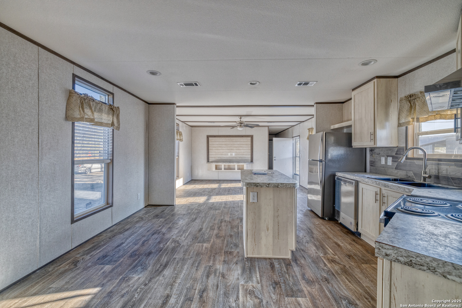 138 Senisa Drive Uvalde, TX 78801 - Photo 9 of 25 a kitchen with granite countertop a stove a sink and a refrigerator