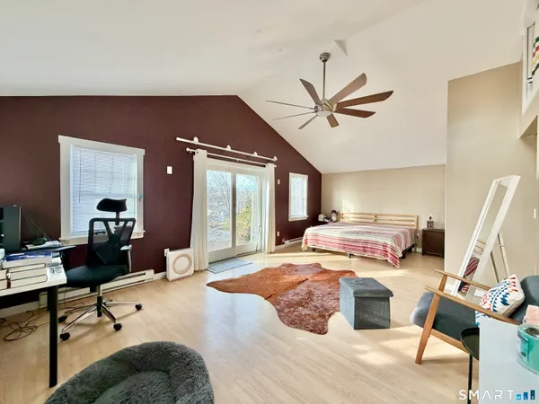 a bedroom with a bed large mirror and a desk