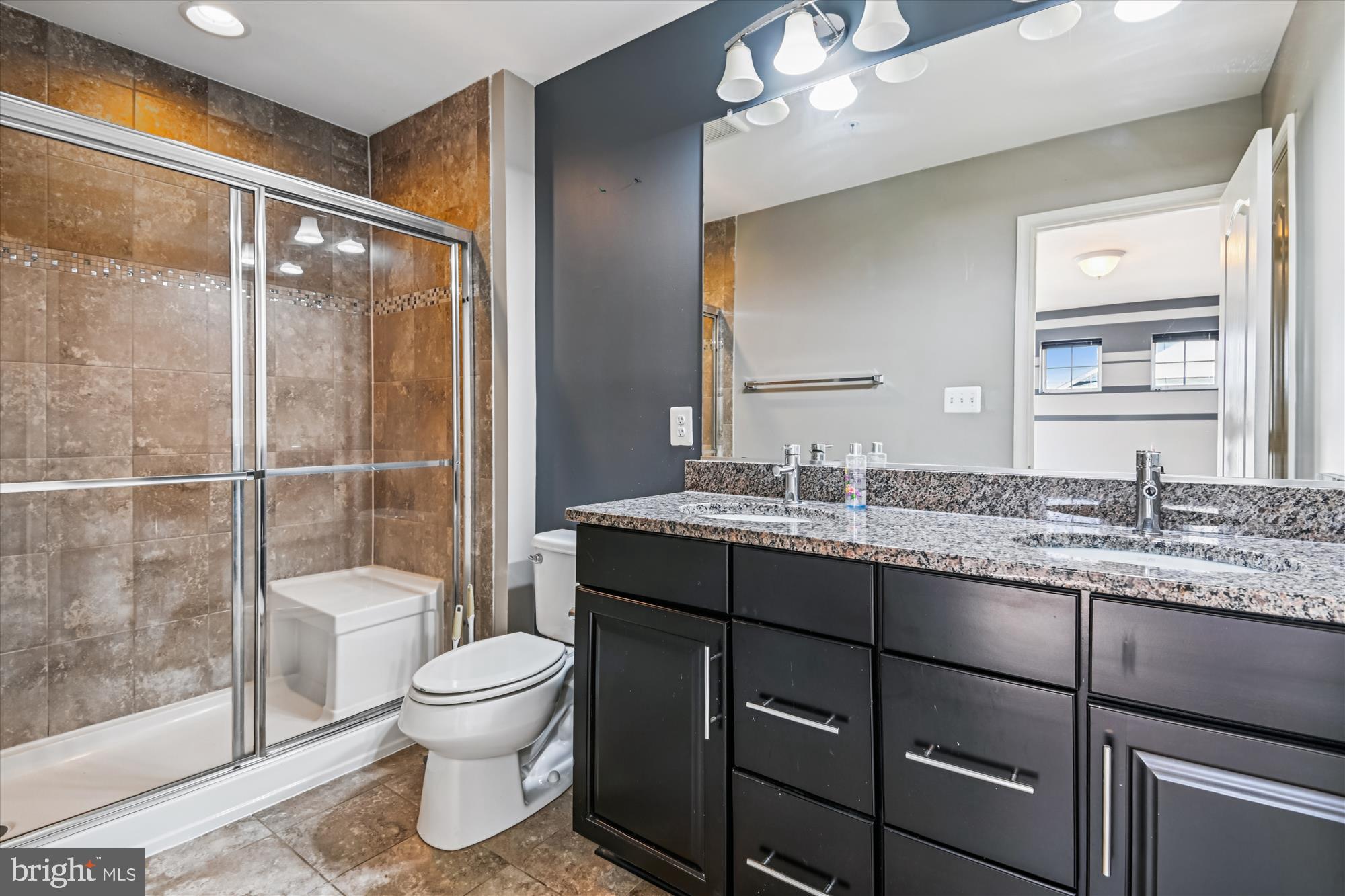 7749 Dagny Way Elkridge, MD 21075 - Photo 18 of 33 a bathroom with a granite countertop sink toilet a mirror and shower