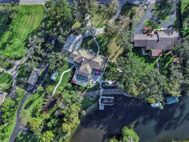 an aerial view of a house with a yard and lake view