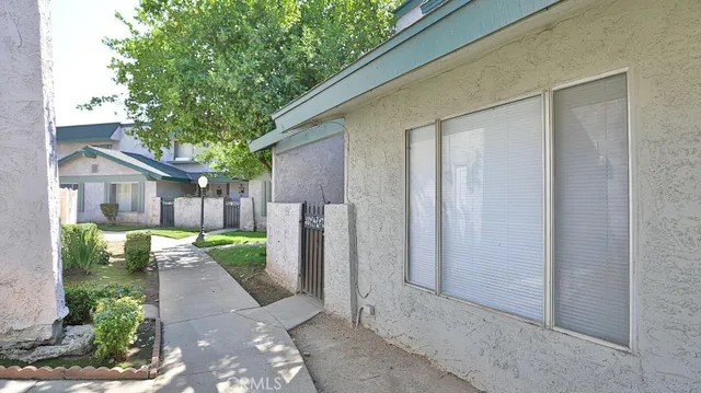 a view of a house with a backyard and a tree