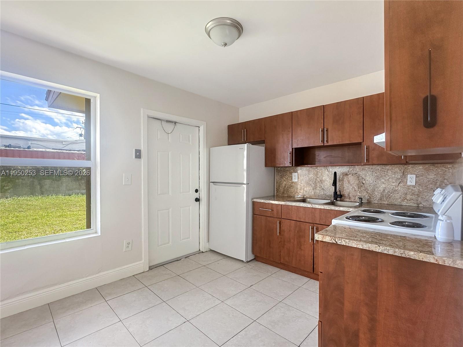 11330 Southwest 207th Drive, Unit LEFT Miami, FL 33189 - Photo 6 of 10 a kitchen with stainless steel appliances granite countertop a refrigerator and a stove top oven