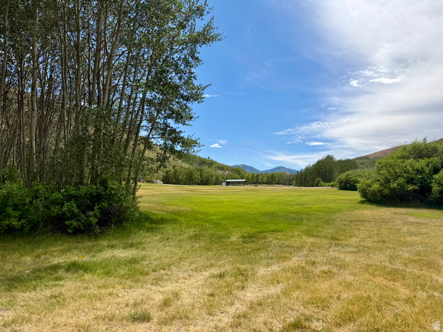 1133 Paris Canyon Road Paris, ID 83261 - Photo 52 of 75 Expansive open field surrounded by mature deciduous trees and distant mountains under a blue sky