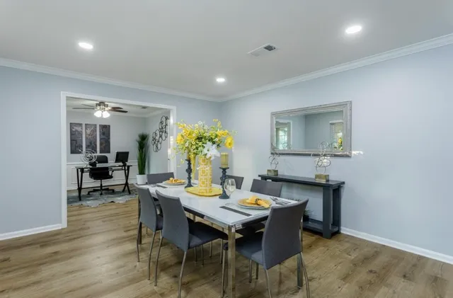 a dining room with furniture a chandelier and wooden floor