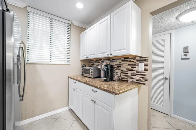 a kitchen with granite countertop a sink and a refrigerator