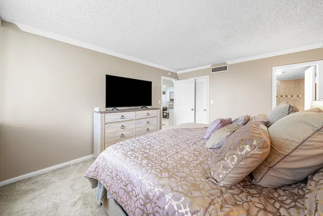 a large bedroom with a bed and a flat screen tv