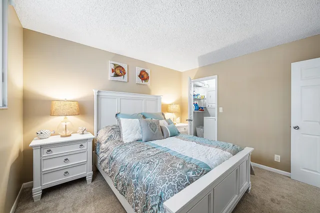 a bedroom with a bed and a lamp on dresser