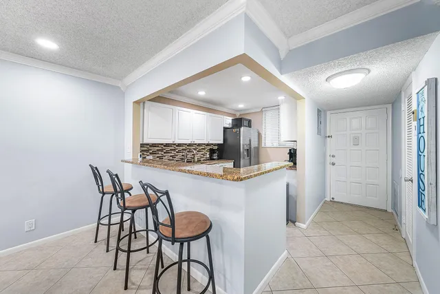 a kitchen with stainless steel appliances kitchen island granite countertop a refrigerator and a stove top oven