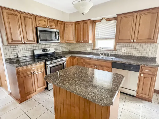 a kitchen with stainless steel appliances granite countertop a sink stove and microwave