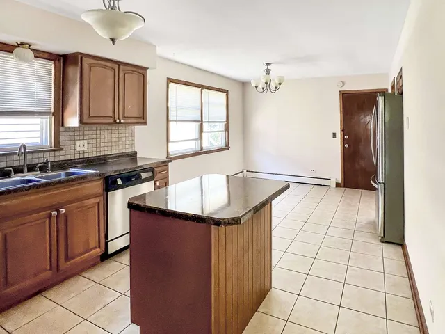 a kitchen with stainless steel appliances granite countertop a sink stove and cabinets